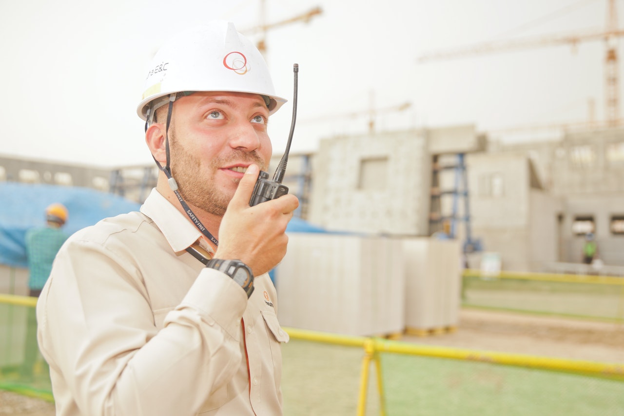 Sap Field Galss Man Wearing White Hard Hat Holding 2 Way Radio 1078879